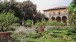 A view across a parterre, with its lemon pots and roman statues, to an arcaded seventeenth-century loggia.