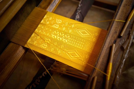 The brocaded spider silk textile being woven