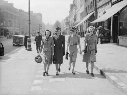 Four women walk down street in Utility clothing © IWM
