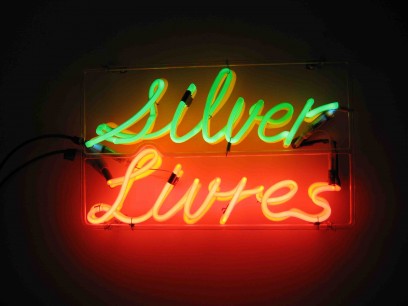 Bruce Nauman. Silver Livres. 1974. Neon tubing with clear glass tubing suspension frame. 30.2×49.7×7 cm. Collection Ealan and Melinda Wingate © 2013 Bruce Nauman/Artists Rights Society, New York